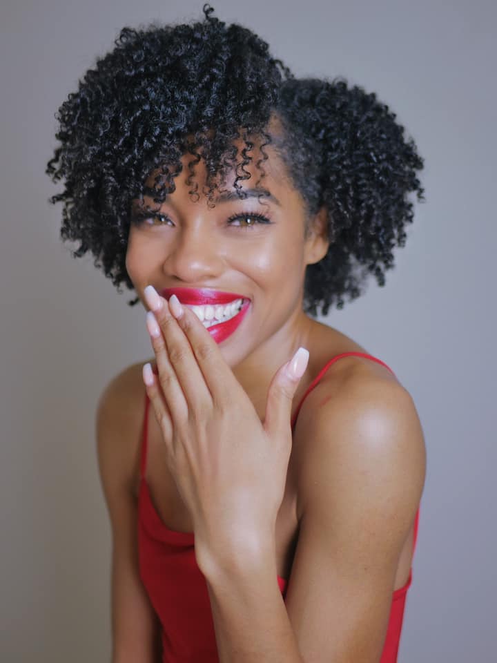 Bria Larine laughing in a red top